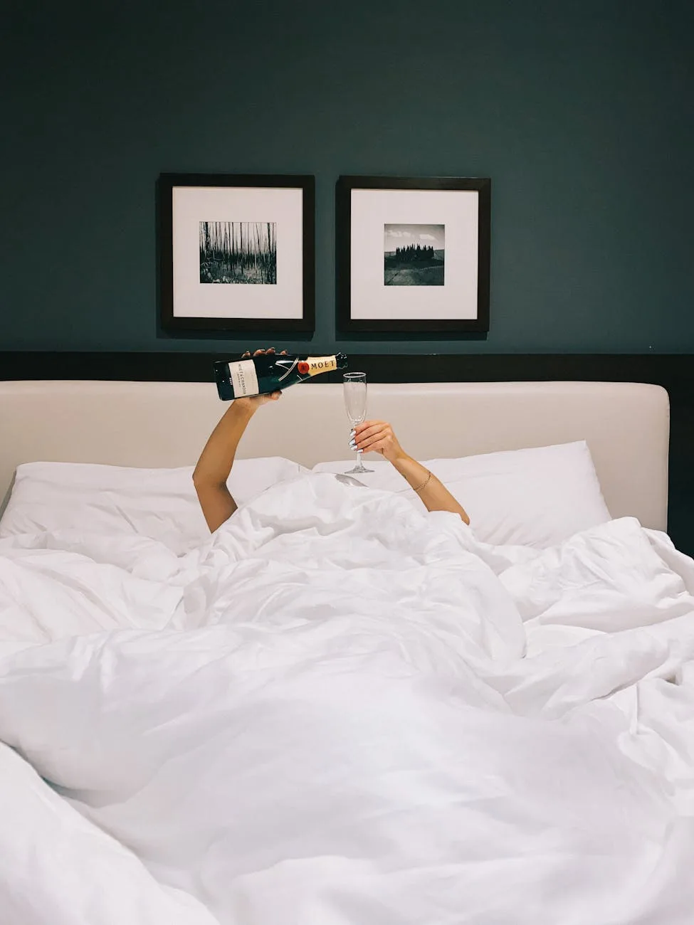 woman pouring champagne in a bed